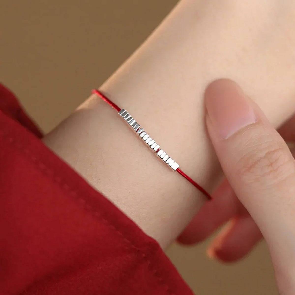 Small silver nugget on a red cord
