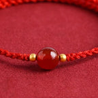 Red string bracelet with love beans
