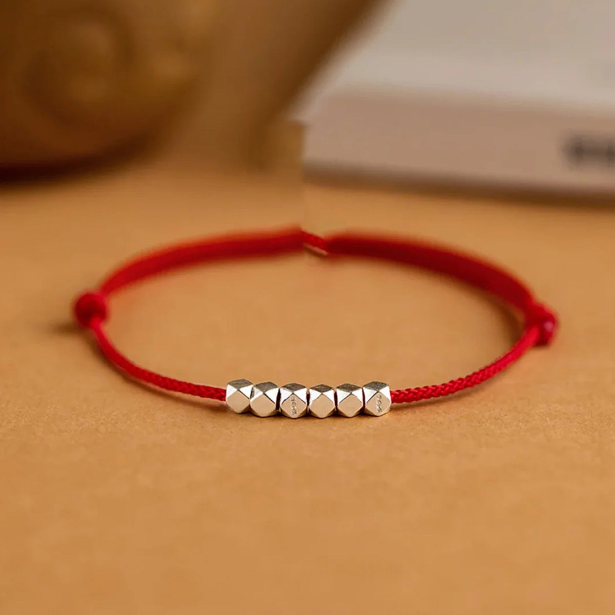 Small silver nugget on a red cord